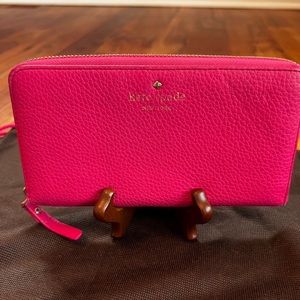 Kate Spade zip around Continental wallet in bright pink.